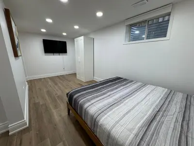 a bedroom with a bed and a flat screen tv at North Barrie !A Stylish and Spacious Private Bedroom with Private Bathroom in Barrie