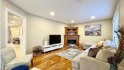 a living room with a couch and a tv at Designer 4BR Retreat, Luxe Living & Family-Friendly Fun in Mississauga