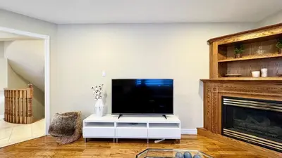 a living room with a tv and a fireplace at Designer 4BR Retreat, Luxe Living & Family-Friendly Fun in Mississauga