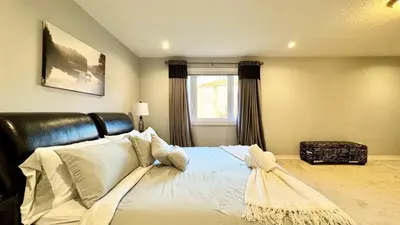 a bedroom with a bed with white pillows and a window at Designer 4BR Retreat, Luxe Living & Family-Friendly Fun in Mississauga