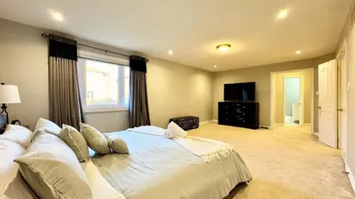 a bedroom with a large white bed with a window at Designer 4BR Retreat, Luxe Living & Family-Friendly Fun in Mississauga