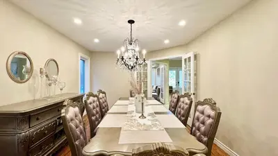 a dining room with a table and chairs and a chandelier at Designer 4BR Retreat, Luxe Living & Family-Friendly Fun in Mississauga