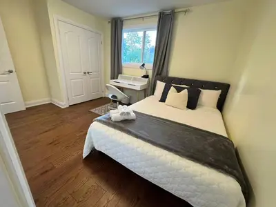 a bedroom with a large bed and a window at Quiet Queen Bedroom near Finch Birchmunt in Toronto