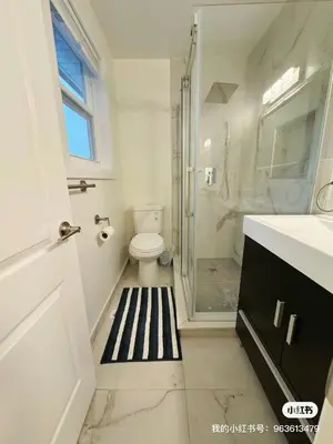 a bathroom with a toilet and a glass shower at Quiet Queen Bedroom near Finch Birchmunt in Toronto