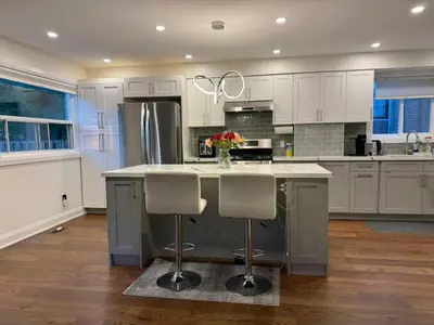 a kitchen with a large island with two bar stools at Quiet Queen Bedroom near Finch Birchmunt in Toronto