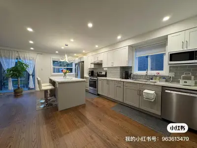 a large kitchen with white cabinets and a kitchen island at Quiet Queen Bedroom near Finch Birchmunt in Toronto