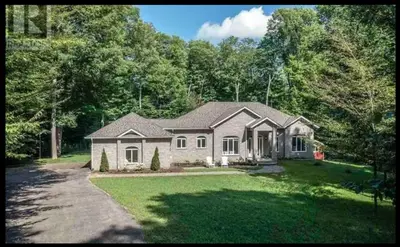 a large house with a large yard with a driveway at Family friendly place with pool in Penetanguishene