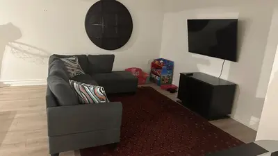 a living room with a couch and a television at Family friendly place with pool in Penetanguishene