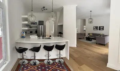 a kitchen and living room with a counter and chairs at Family friendly place with pool in Penetanguishene