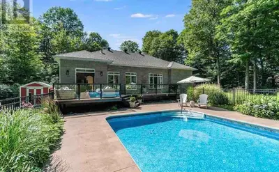 a swimming pool in front of a house at Family friendly place with pool in Penetanguishene