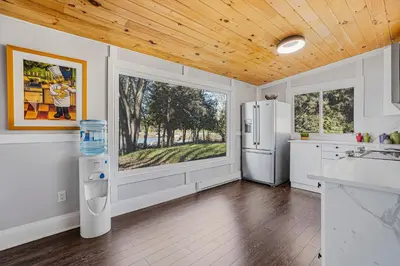 a kitchen with white appliances and a wooden ceiling at Rustic Lakefront Cottage with Fire Pit & Scenic Views in Brechin