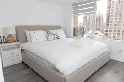 a white bedroom with a large bed and a window at PlanURstay - Ideal 2BR & 2 BTH - Near SQ1 Mall in Mississauga