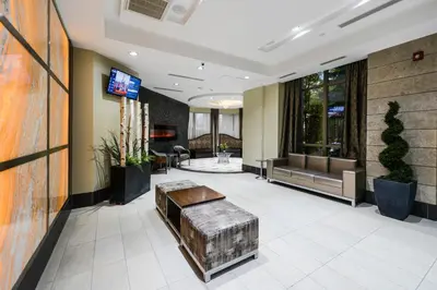 a lobby of a hotel with a bench and a tv at PlanURstay - Ideal 2BR & 2 BTH - Near SQ1 Mall in Mississauga