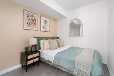 a white bedroom with a bed and a mirror at Chic 2BR Condo Toronto Core Steps to Eaton Centre in Toronto