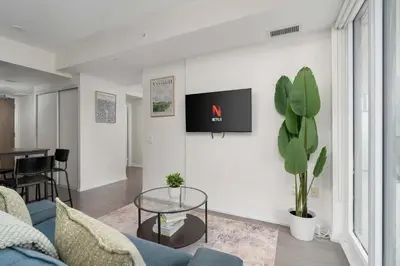 a living room with a blue couch and a glass table at Chic 2BR Condo Toronto Core Steps to Eaton Centre in Toronto