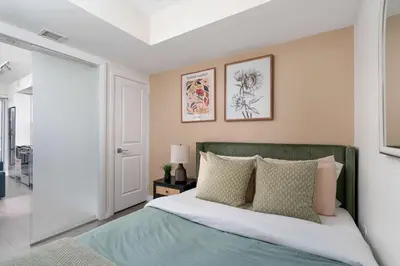 a bedroom with a bed with a green headboard at Chic 2BR Condo Toronto Core Steps to Eaton Centre in Toronto