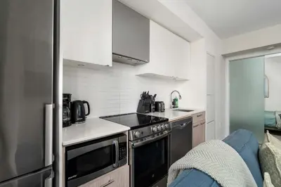 a kitchen with a sink and a stove top oven at Chic 2BR Condo Toronto Core Steps to Eaton Centre in Toronto