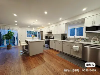 a large kitchen with stainless steel appliances and wood floors at Quite room finch birchmunt in Toronto