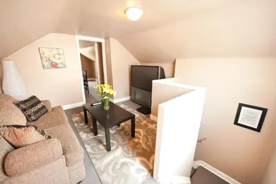 a living room with a couch and a tv at Misty Retreat in Niagara Falls