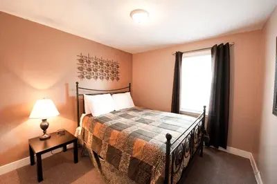 a bedroom with a bed and a window at Misty Retreat in Niagara Falls