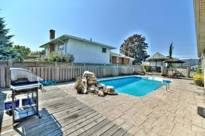 a backyard with a swimming pool and a fence at STONEHAVEN RETREAT in Niagara Falls