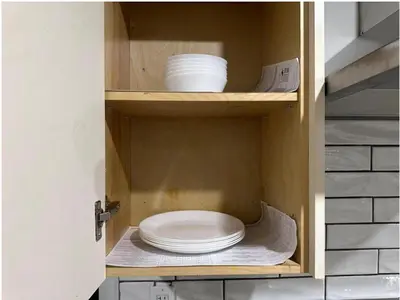 a cabinet with a stack of plates and bowls in it at 1-Bedroom 1Bathroom Entire Unit closer to Fairview Mall & Waterloo Airport in Kitchener
