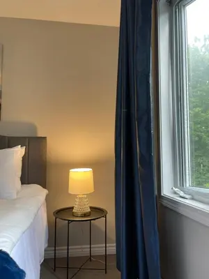 a bedroom with a bed and a table with a lamp at Academic Oasis in London