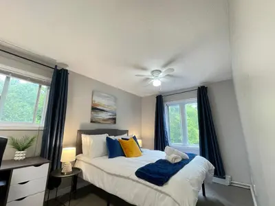 a bedroom with a bed with blue and yellow pillows at Academic Oasis in London
