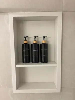 three black bottles sitting on a shelf in a wall at Academic Oasis in London