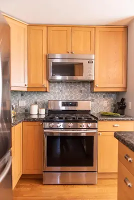 a kitchen with a stainless steel oven and microwave at New York Style Brownstone Elegant Home in Toronto's Vibrant King West in Toronto