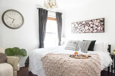 a bedroom with a bed and a clock on the wall at New York Style Brownstone Elegant Home in Toronto's Vibrant King West in Toronto