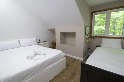 a bedroom with two beds and a window at Spacious 4 Bdrm, Lake Views, Steps from the Beach in Tiny