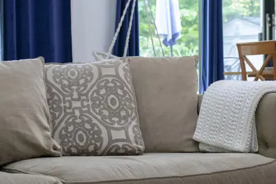 a couch with two pillows on it in a living room at Spacious 4 Bdrm, Lake Views, Steps from the Beach in Tiny