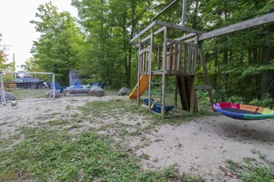 a playground with a slide and a swing at Spacious 4 Bdrm, Lake Views, Steps from the Beach in Tiny