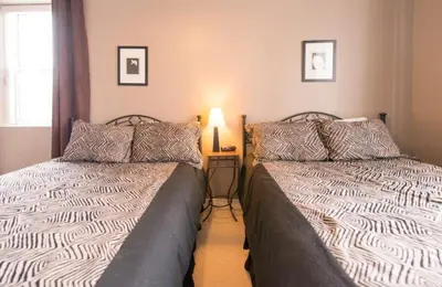 two beds sitting next to each other in a bedroom at PRESIDENTIAL SUITE in Niagara Falls
