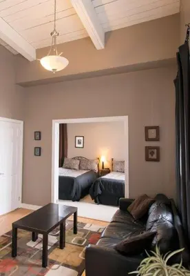 a living room with a couch and a room with two beds at PRESIDENTIAL SUITE in Niagara Falls