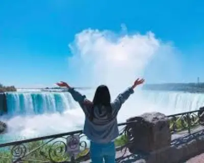 a woman standing in front of a waterfall at RIVERSIDE STAY in Niagara Falls