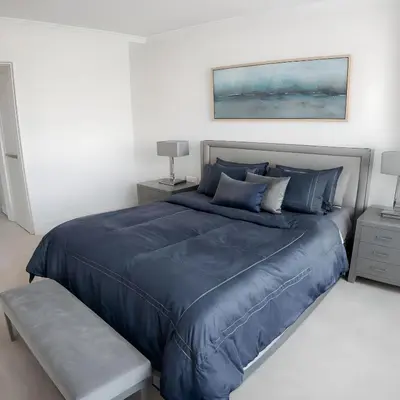 a bedroom with a blue bed with a blue comforter at RIVERSIDE STAY in Niagara Falls