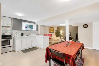 a kitchen and living room with a table with a red table cloth at Cozy Private Basement Suite Beside Plaza Free Parking Walk to Groceries & Dining in Richmond Hill