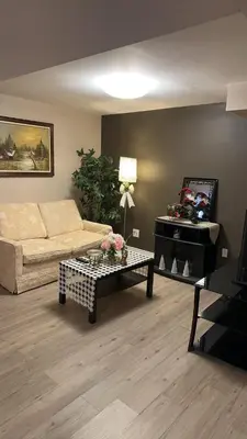 a living room with a couch and a table at Cozy Private Basement Suite Beside Plaza Free Parking Walk to Groceries & Dining in Richmond Hill