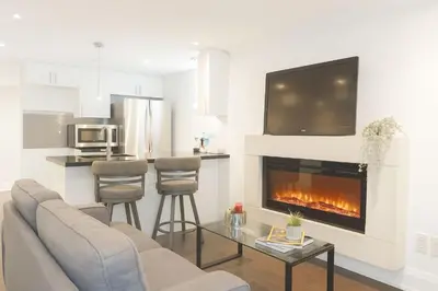 a living room with a couch and a fireplace at Bright 2 Bed Basement Near Square One Mall Family Friendly Stay in Mississauga