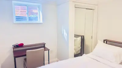 a bedroom with a bed and a desk and a window at Bright 2 Bed Basement Near Square One Mall Family Friendly Stay in Mississauga
