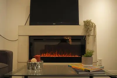 a living room with a fireplace with a tv above it at Bright 2 Bed Basement Near Square One Mall Family Friendly Stay in Mississauga