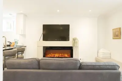 a living room with a couch and a fireplace at Bright 2 Bed Basement Near Square One Mall Family Friendly Stay in Mississauga