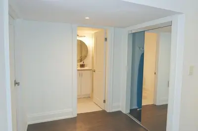 a hallway with a mirror in a room at Bright 2 Bed Basement Near Square One Mall Family Friendly Stay in Mississauga