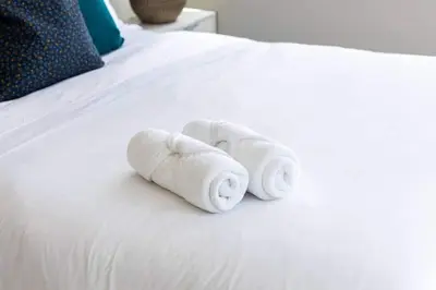 a stack of towels sitting on a bed at Spacious 3BR Loft with Balcony and Free Parking in Toronto