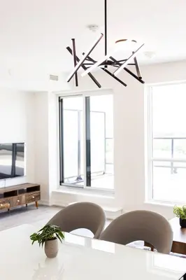 a dining room with a table and chairs and a chandelier at Spacious 3BR Loft with Balcony and Free Parking in Toronto