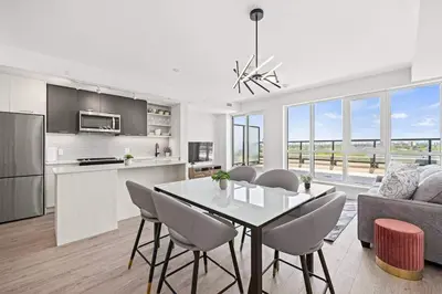 a kitchen and living room with a table and chairs at Spacious 3BR Loft with Balcony and Free Parking in Toronto