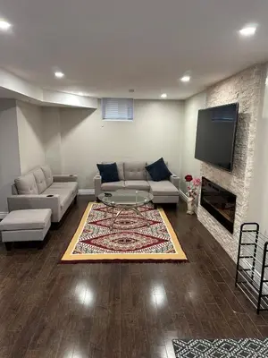 a living room with a couch and a tv at Cozy and comfy 2 Bed rooms in Mississauga