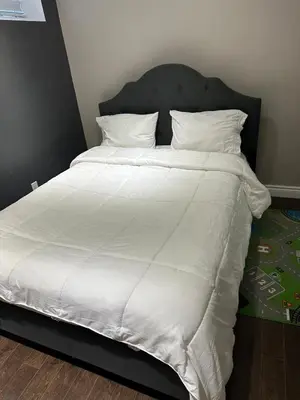 a large white bed with white sheets and pillows at Cozy and comfy 2 Bed rooms in Mississauga